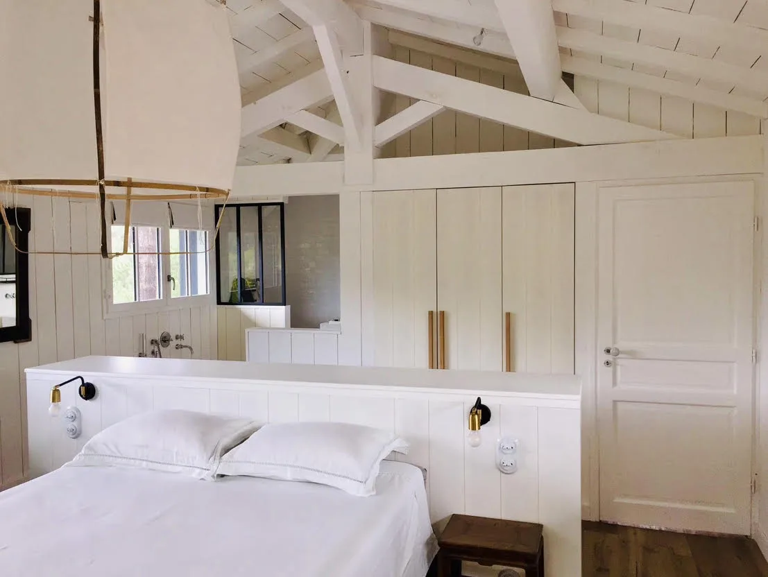 Chambre sur mesure, placards intégrés en chêne sous charpente blanche, esprit bassin