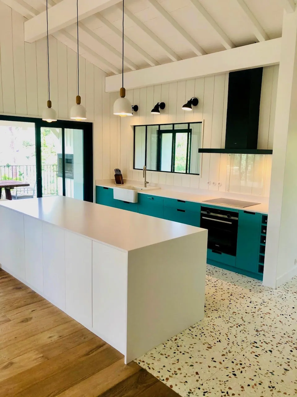 Cuisine sur mesure bleu canard, îlot blanc et verrière atelier, esprit bassin