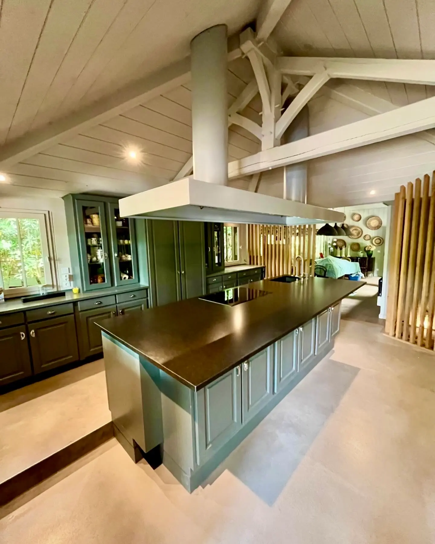Cuisine sur mesure verte sous charpente bois, esprit bassin