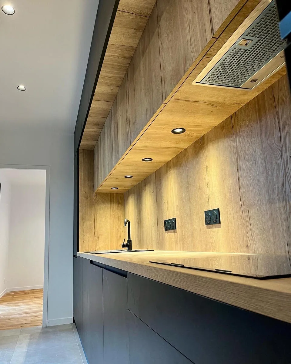 Agencement cuisine sur mesure, façades noires et crédence bois rétroéclairée