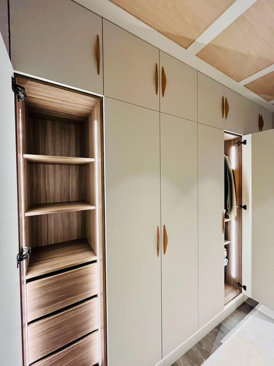 Dressing sur mesure beige, niche centrale en bois éclairée LED et poignées bois, Technibois Agencement